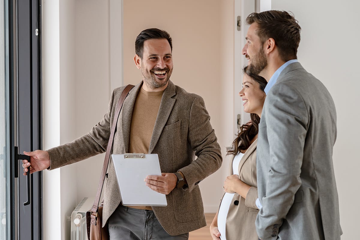 Eine Verkaufsberaterin zeigt ihren Gästen die neu gebaute Immobilie