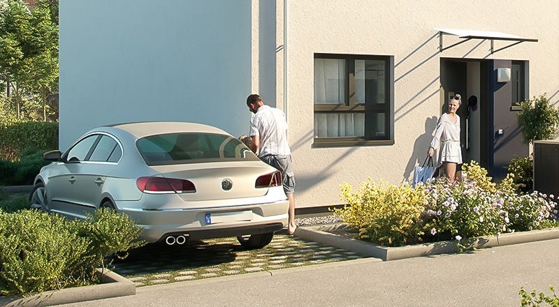 Auto parkt vor einem neu gebauten Haus