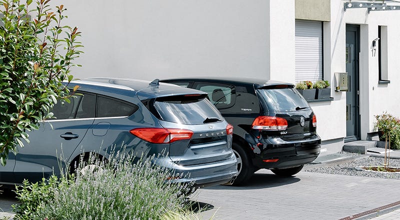 Auto parkt vor einem neu gebauten Haus