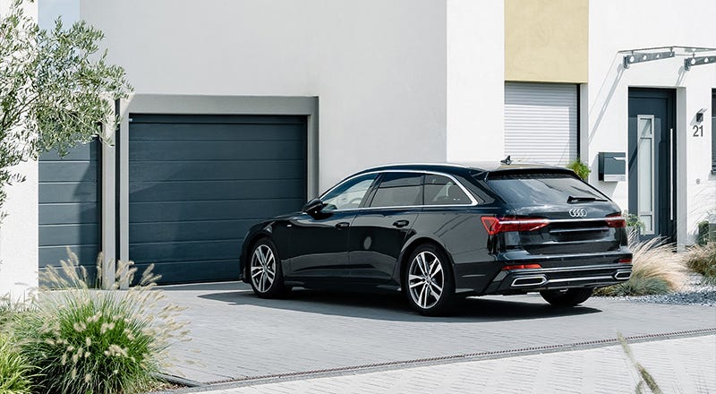 Auto parkt vor einer Garage vor einem neu gebauten Haus